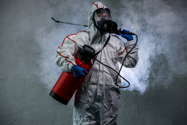 дезинфектор использует специальные опрыскиватели и микробы во время пандемии коронавируса
