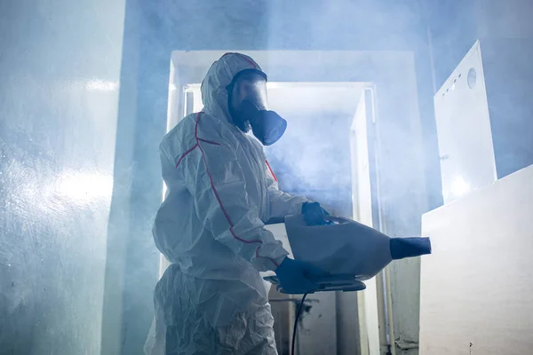 Pandemia mundial COVID-19. desinfetador em terno dentro de casa — Fotografia de Stock