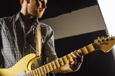 Yakışıklı adam elektro gitar çalmaktan hoşlanıyor.