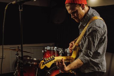 Yakışıklı adam elektro gitar çalmaktan hoşlanıyor.