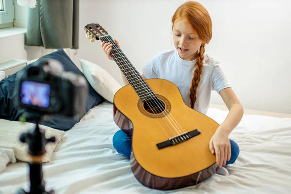 Hermoso lindo caucásico niño blogger jugar guitarra en cámara —  Fotos de Stock