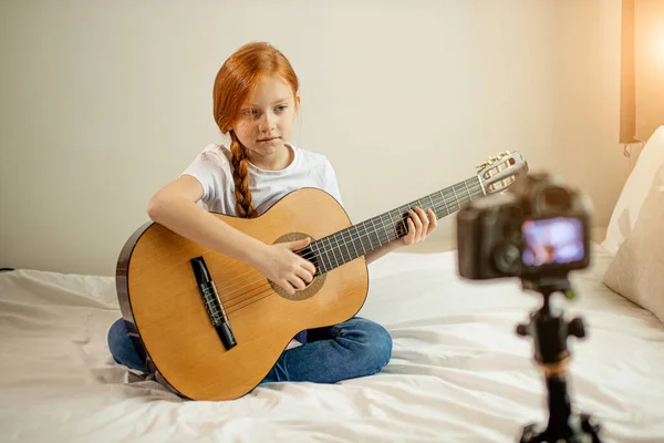 Hermoso lindo caucásico niño blogger jugar guitarra en cámara —  Fotos de Stock