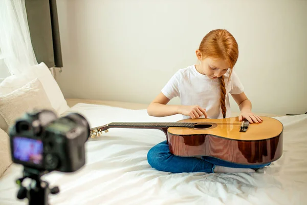 Милый очаровательный ребенок блоггер играть на гитаре — стоковое фото