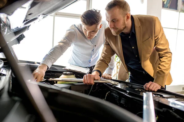 Vendedor de coches caucásicos muestran la mejor variante para el cliente — Foto de Stock