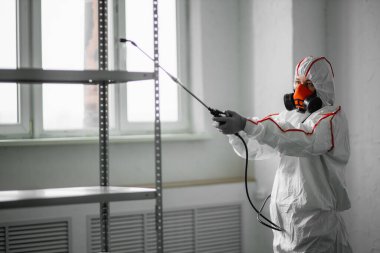 Dünya salgını COVID-19. Takım elbiseli dezenfektan.