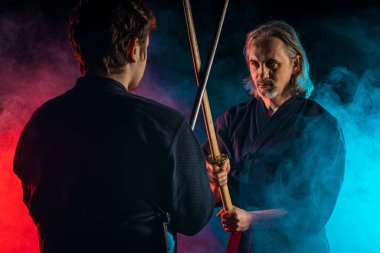İki Kendo savaşçısı karşı karşıya ve Shinai karanlık uzayda izole edilmiş.