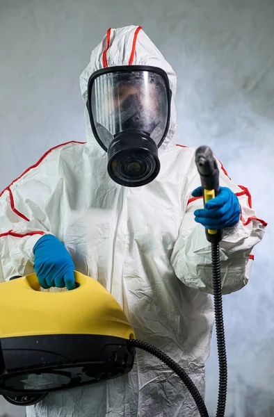 Disinfektor menggunakan penyemprot dan kuman isinfektan khusus selama epidemi pandemi coronavirus — Stok Foto