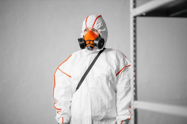 Desinfector met biologisch beschermend pak en gasmasker voeren desinfectie uit — Stockfoto