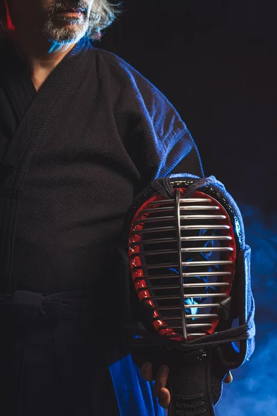 Foto recortada del hombre sosteniendo casco kendo — Foto de Stock