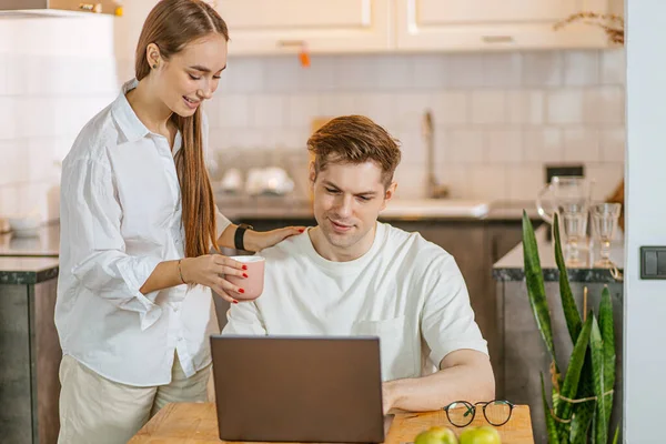Esposa cuidadosa apoiar seu marido enquanto ele está trabalhando em casa — Fotografia de Stock