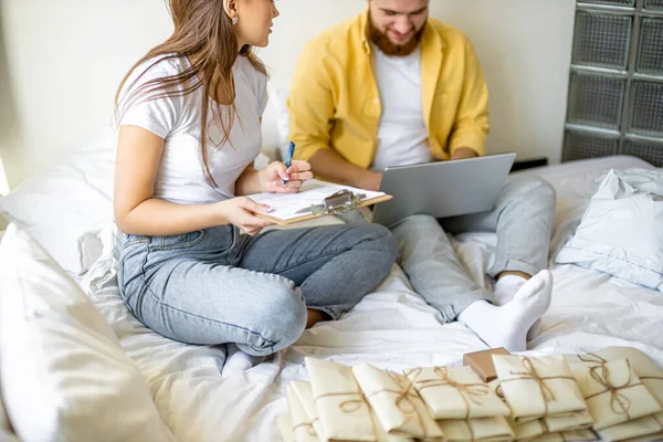 Jovem casal sentar cartas de classificação, convites em casa — Fotografia de Stock