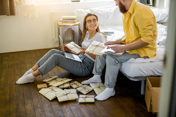 Jovem casal preparando convites para casamento em casa — Fotografia de Stock