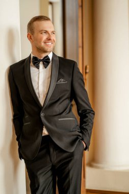 Smokinli gülümseyen beyaz adam.