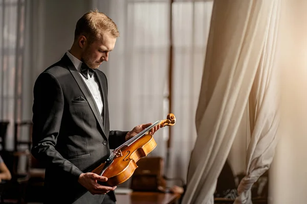 professional violinist studying and checking violin strings