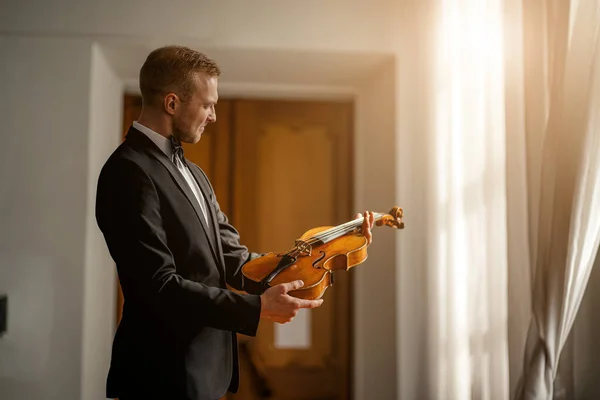 young male violinist hold violin in hands