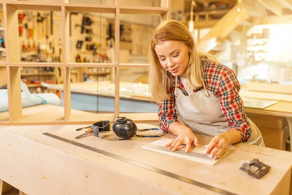 Atractiva señora carpintero se ocupa de dibujos durante el trabajo — Foto de Stock