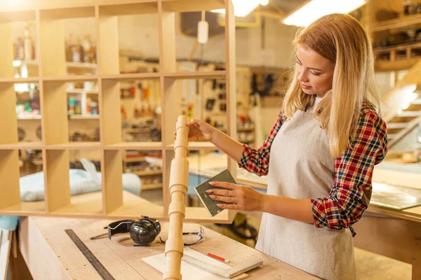 Diligente mujer moliendo pieza de madera — Foto de Stock