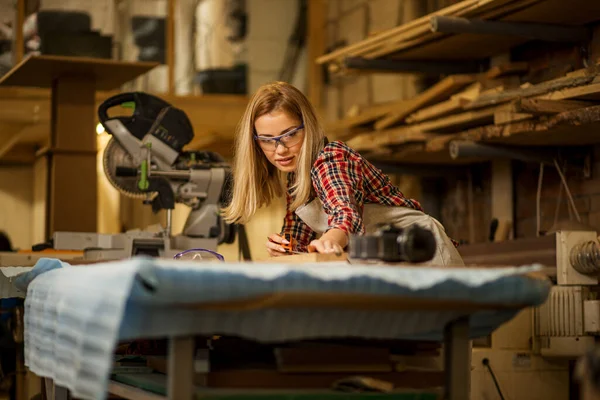 Hermosa mujer caucásica carpintero trata con artesanía — Foto de Stock