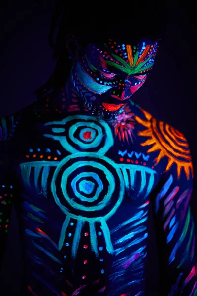 Strong muscular male covered with fluorescent luminescence body art — Stock Photo, Image