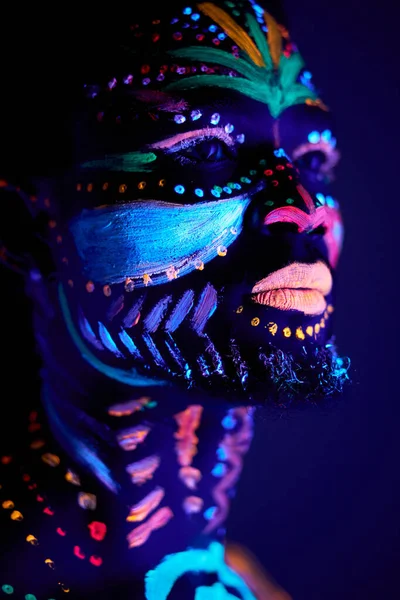 Close-up black female with fluorescent prints on skin, cosmic paint glowing  on neon lights Stock Photo by ©ufabizphoto 543170308