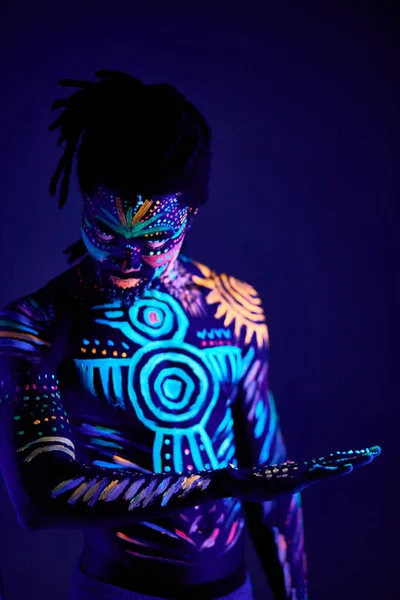 Afrikansk man målad i fluorescerande färg på ansikte och muskulös bål — Stockfoto