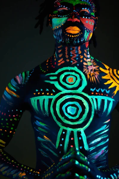 Retrato conceptual del hombre africano pintado en colores UV fluorescentes —  Fotos de Stock