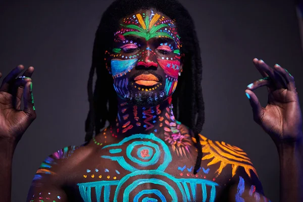 Konzeptporträt eines ruhigen Afrikaners, gemalt in fluoreszierenden UV-Farben — Stockfoto