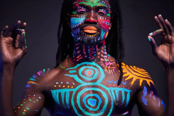 Retrato do homem africano com padrão étnico, maquiagem de néon em luz ultravioleta — Fotografia de Stock