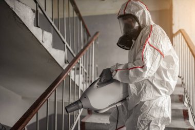 Koruyucu tehlikeli madde giysisi giyen virolog dezenfeksiyon uyguladı