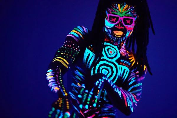 Schwarzer Mann in fluoreszierenden Mustern tanzt in ultraviolettem Licht — Stockfoto