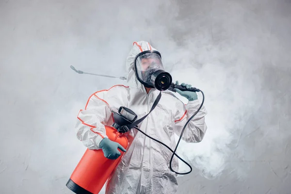 Wereldpandemie COVID-19. desinfector in pak binnenshuis — Stockfoto
