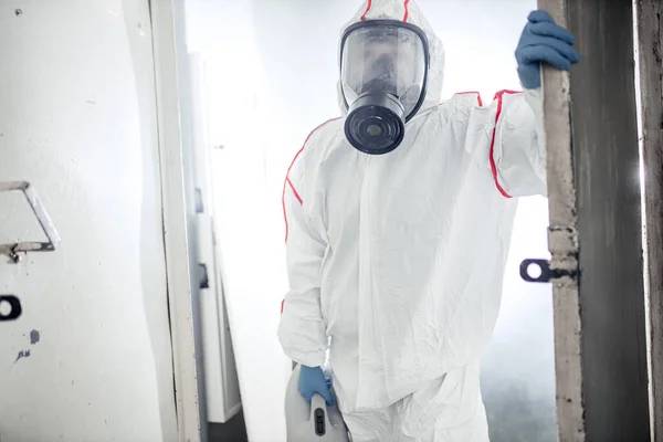 Άνδρας σε ένα NBC μέσα ατομικής προστασίας εξοπλισμός ppe κοστούμι καθαρισμού απομονωμένο χώρο — Φωτογραφία Αρχείου