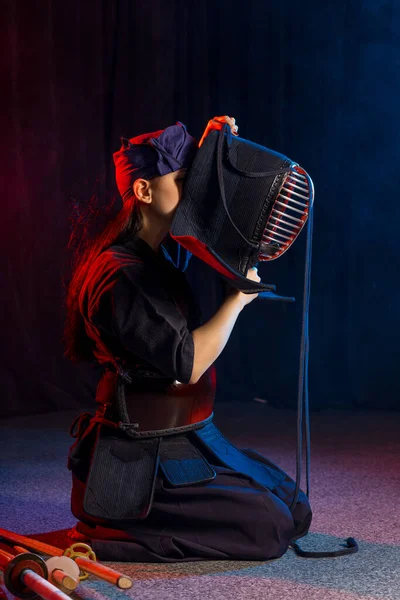 Νεαρή γυναίκα kendo μαχητής φορούν κράνος μάσκα στο κεφάλι — Φωτογραφία Αρχείου