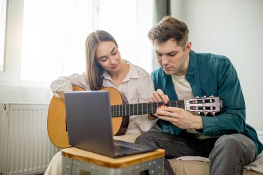 Güzel beyaz çift gitar çalma dersleri alıyor.