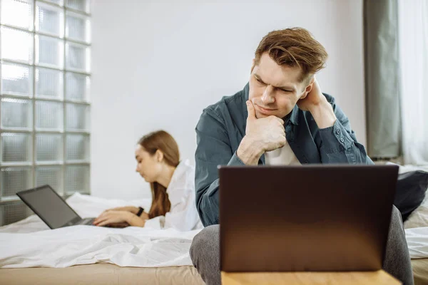 Junge kaukasische Paare nutzen Laptop, arbeiten zu Hause, sind mit ihrem eigenen Geschäft beschäftigt — Stockfoto