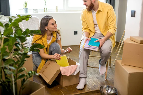 Joven feliz pareja desembalaje cajas de cartón después de mudarse en nueva casa —  Fotos de Stock