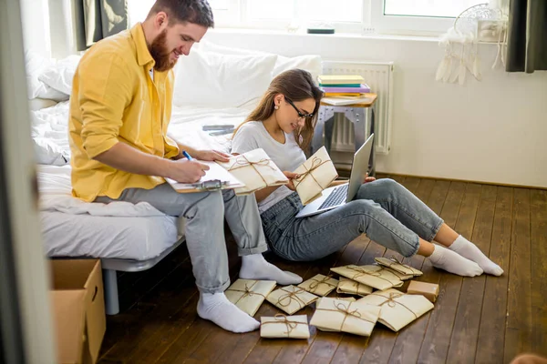 Feliz casal caucasiano classificando letras em casa — Fotografia de Stock