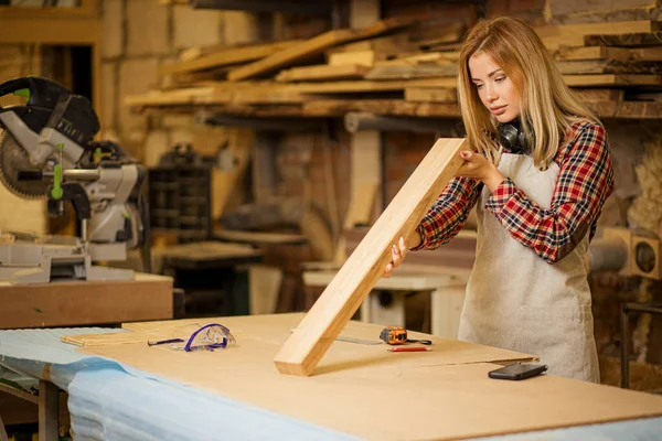 Joven mujer carpintero caucásico chequeo pieza de madera — Foto de Stock