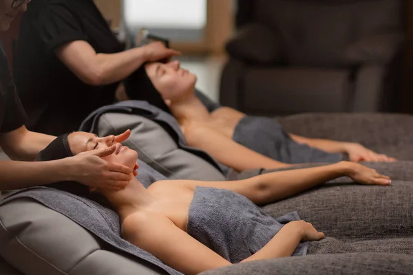 Twee aantrekkelijke vrouwen worden verwend zichzelf in de gezondheid spa, krijgen facelift massage — Stockfoto
