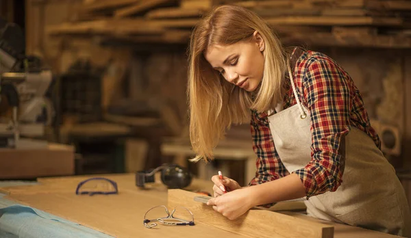 Hermosa mujer caucásica carpintero trata con artesanía — Foto de Stock