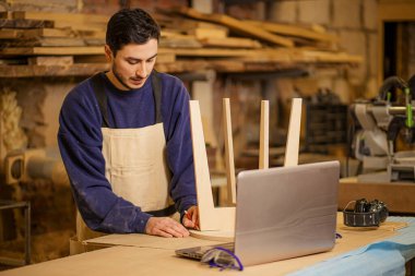 Kafkas mobilya üreticisi ustalıkla ahşap bir sandalye yapıyor.