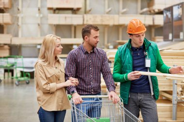 Yakışıklı işçi alanında uzmandır, alıcılara danışır.