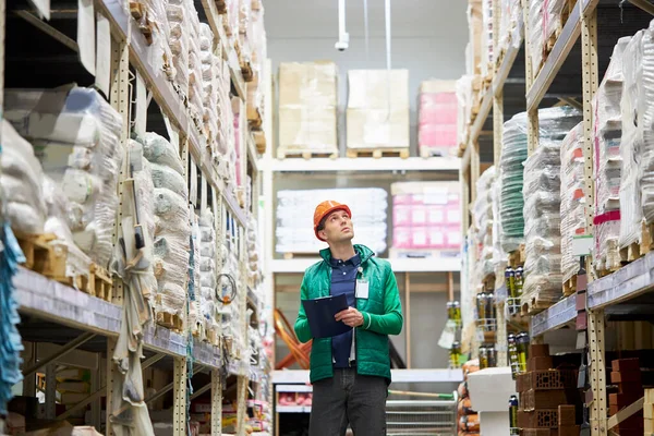 自信のある倉庫労働者が市場で商品の数量をチェック — ストック写真