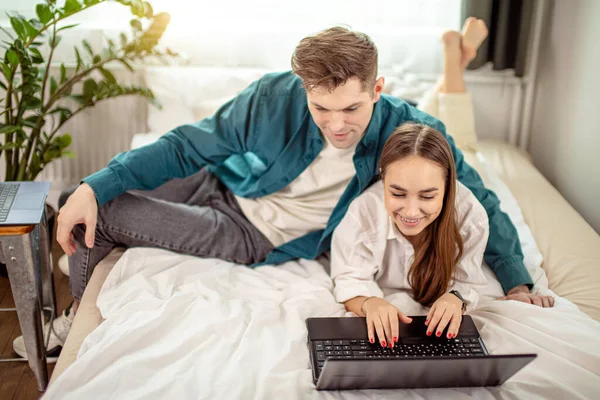 一对年轻夫妇在家里的笔记本电脑上看电影 — 图库照片
