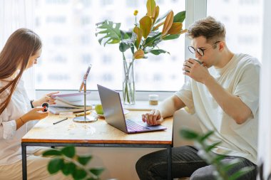 Güzel bayan sabah makyajını yaparken kocası laptopta çalışıyor.