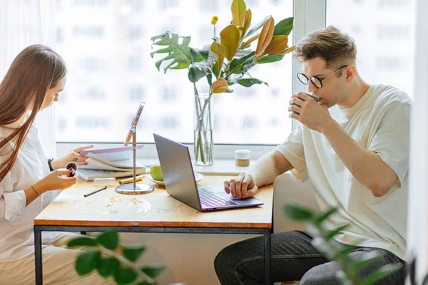 아름다운 여인은 남편 이 노트북으로 일하는 동안 아침에 화장을 한다 — 스톡 사진