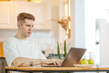 Genç beyaz adam evde çalışıyor.