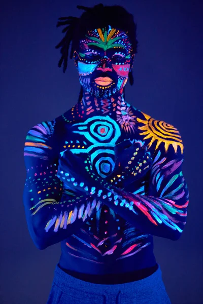 Afrikaner mit fluoreszierender Farbe auf Gesicht und muskulösen Oberkörper gemalt — Stockfoto