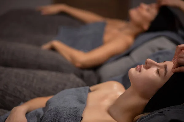 Damas caucásicas descansan durante masaje lifting facial en spa — Foto de Stock