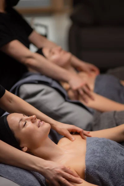 Професійний косметолог, що робить масаж обличчя для жінки в салоні — стокове фото